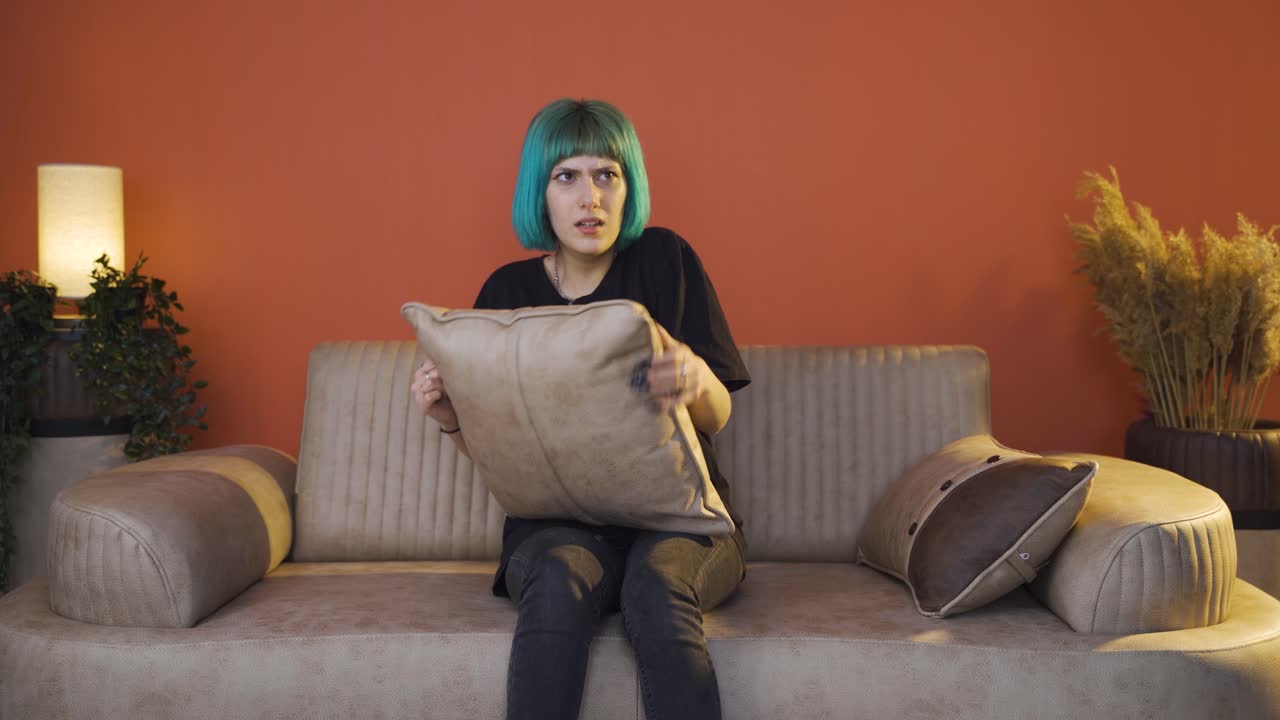 la joven que presiona las almohadas en su cabeza con miedo.