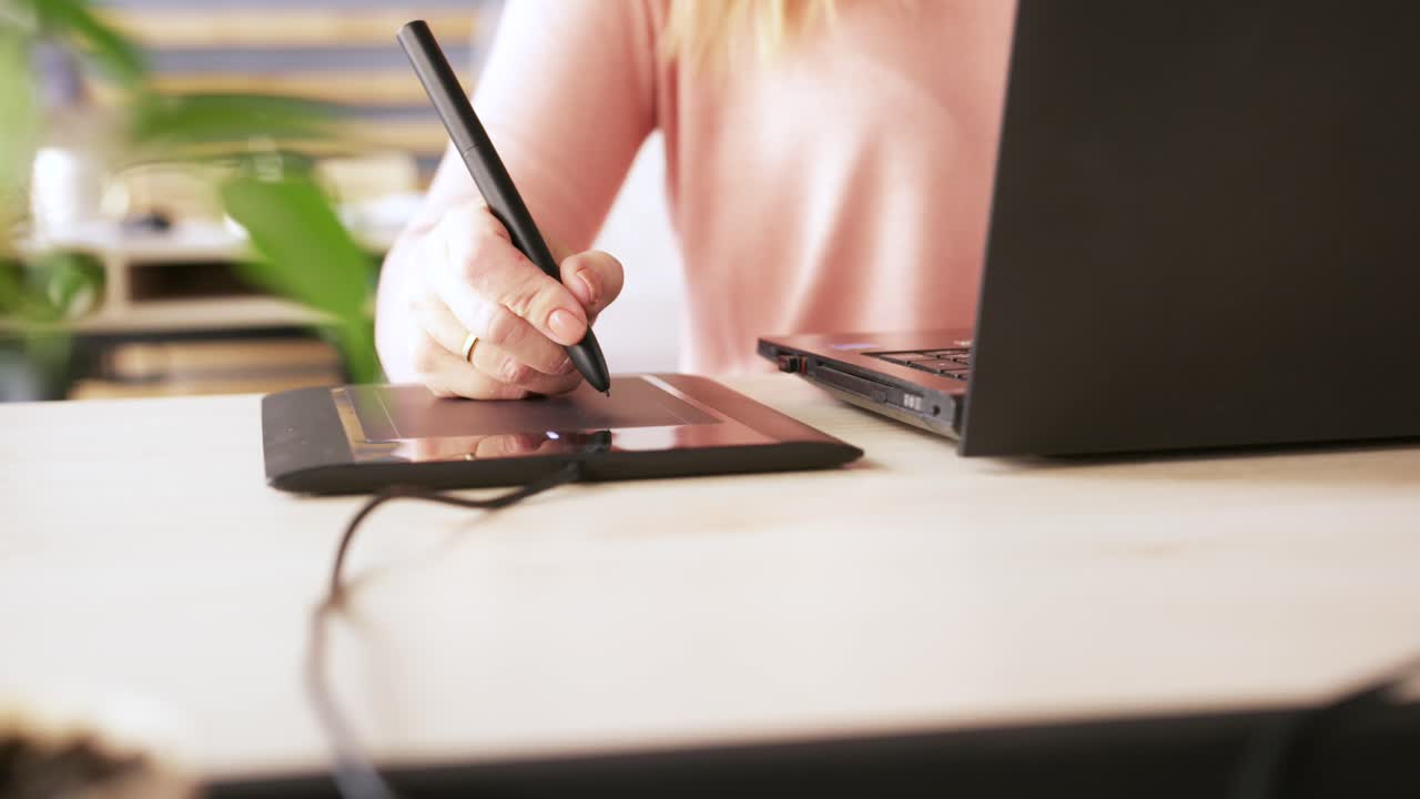 Woman using a graphics tablet and laptop