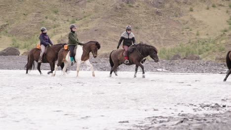 Grupo-De-Turistas-A-Caballo-A-Través-De-Aguas-Poco-Profundas-En-El-Valle-De-Thórsmörk