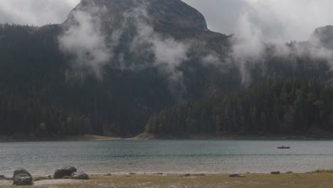 mountain lake with fog and canoe