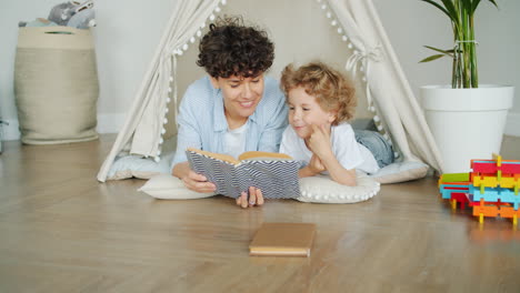mother and son reading together in a teepee