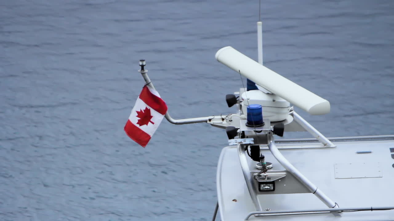 bandera canadiense en un pequeño bote flotando en un puerto