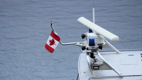 canadian flag on a small boat bobbing in a harbour