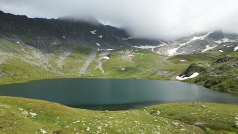 drone shot of the lake of fenêtre in the swiss alps with snow in the summer