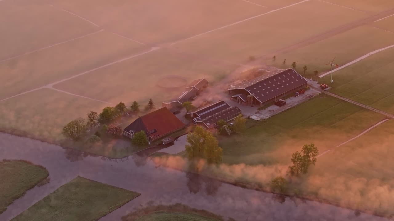 Luftfoto af tåget solopgang over landbrugsjord og vandløb i Wergea