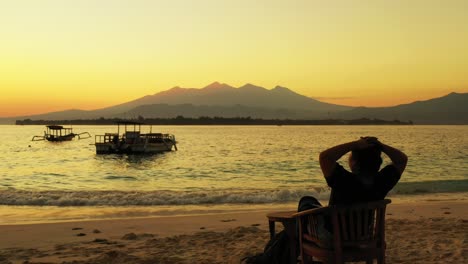 Bermida-islands,-woman-relaxing-in-the-bar-on-the-beachfront-on-the-beautiful-golden-sunset