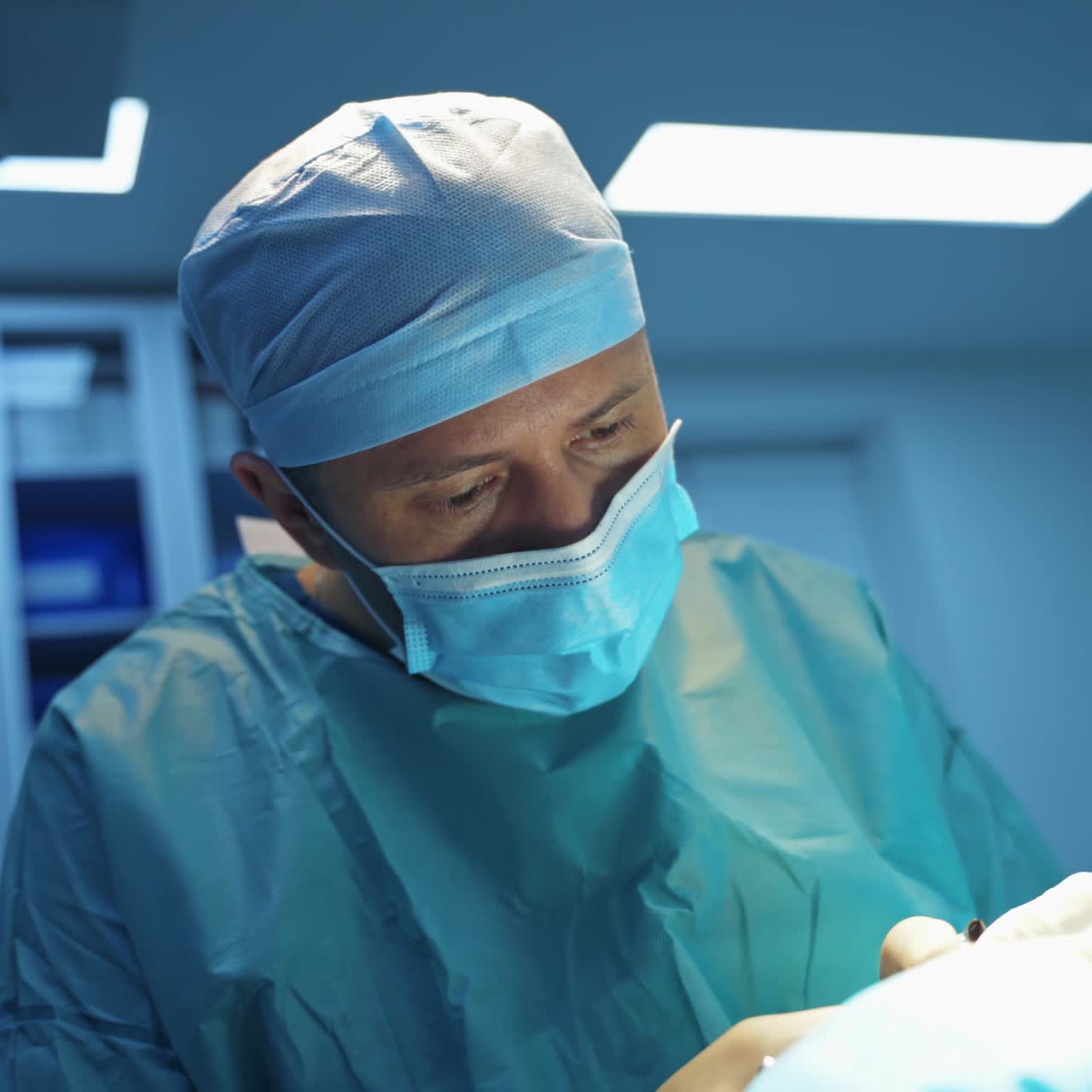 Blepharoplasty operation. Surgeon puts stitches on the patient's eye. Plastic surgeon operates on a patient in the operating room.