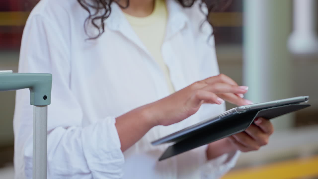 mujer usando una tableta en la estación de tren