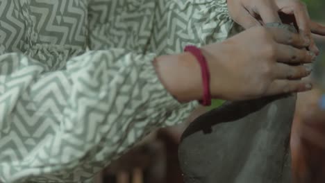a potter shapes clay with skilled hands in a close-up shot, emphasizing traditional craftsmanship