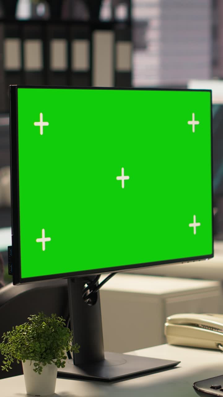 Stationær computerskærm med grøn skærm på kontor.