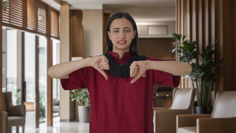 upset indian female housekeeper showing thumbs down