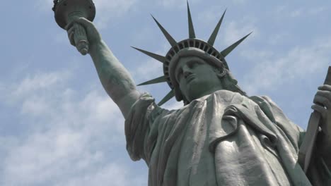 time lapse tilt up of clouds behind the statue of liberty in this shot which says patriotism and patriotic values