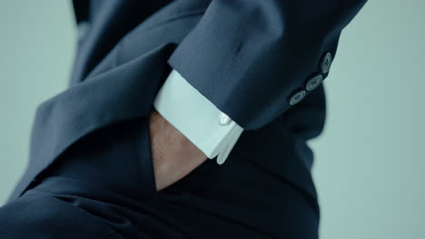 close up male in black and white suit while putting hand in the pocket of trouser inside office