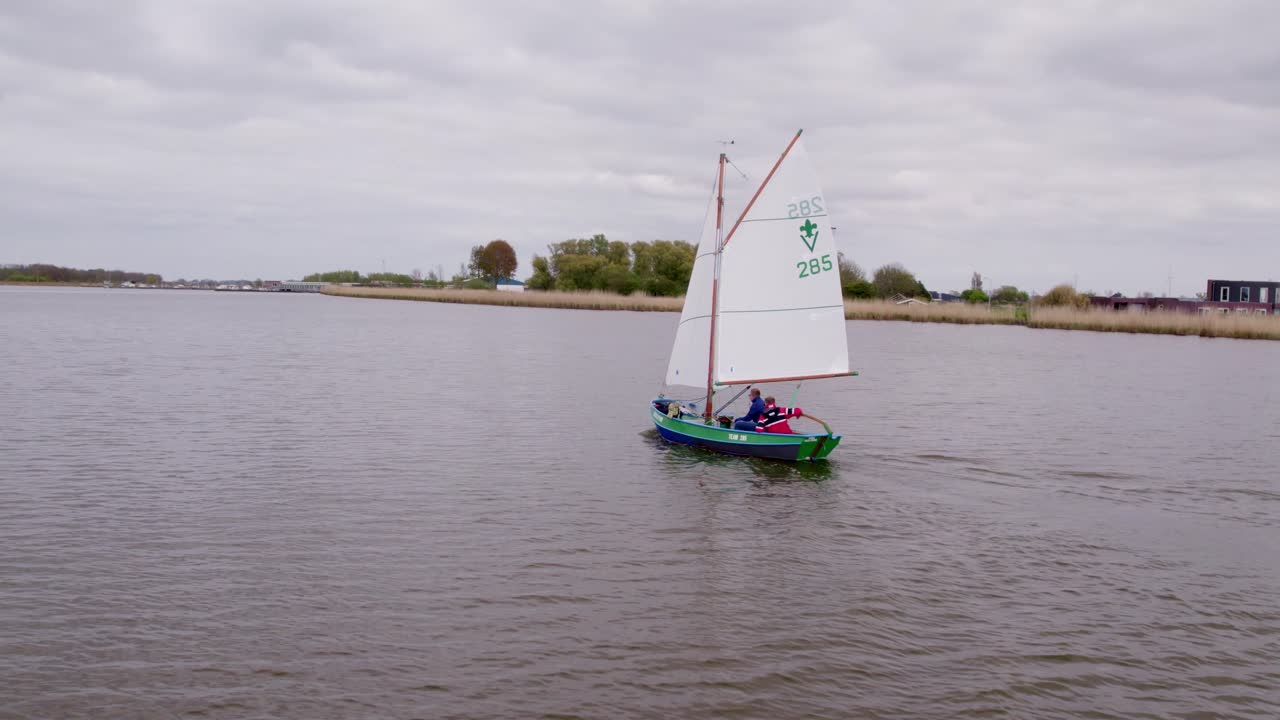 Aerial view of river and windmill with sailboat, Anna Paulowna, Netherlands