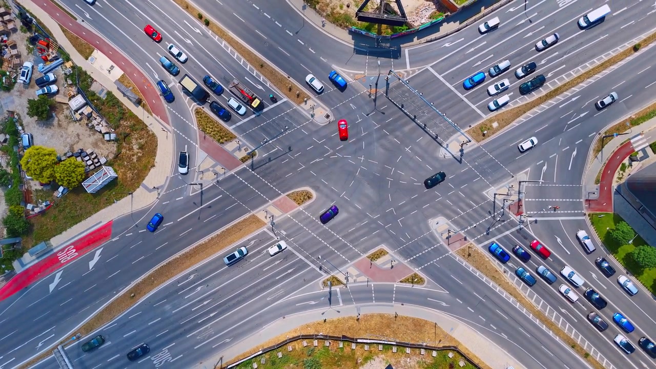 Aerial view of a busy city intersection, Bratislava, Slovakia. Top down drone perspective of asphalt road lanes with driving cars on a sunny day.