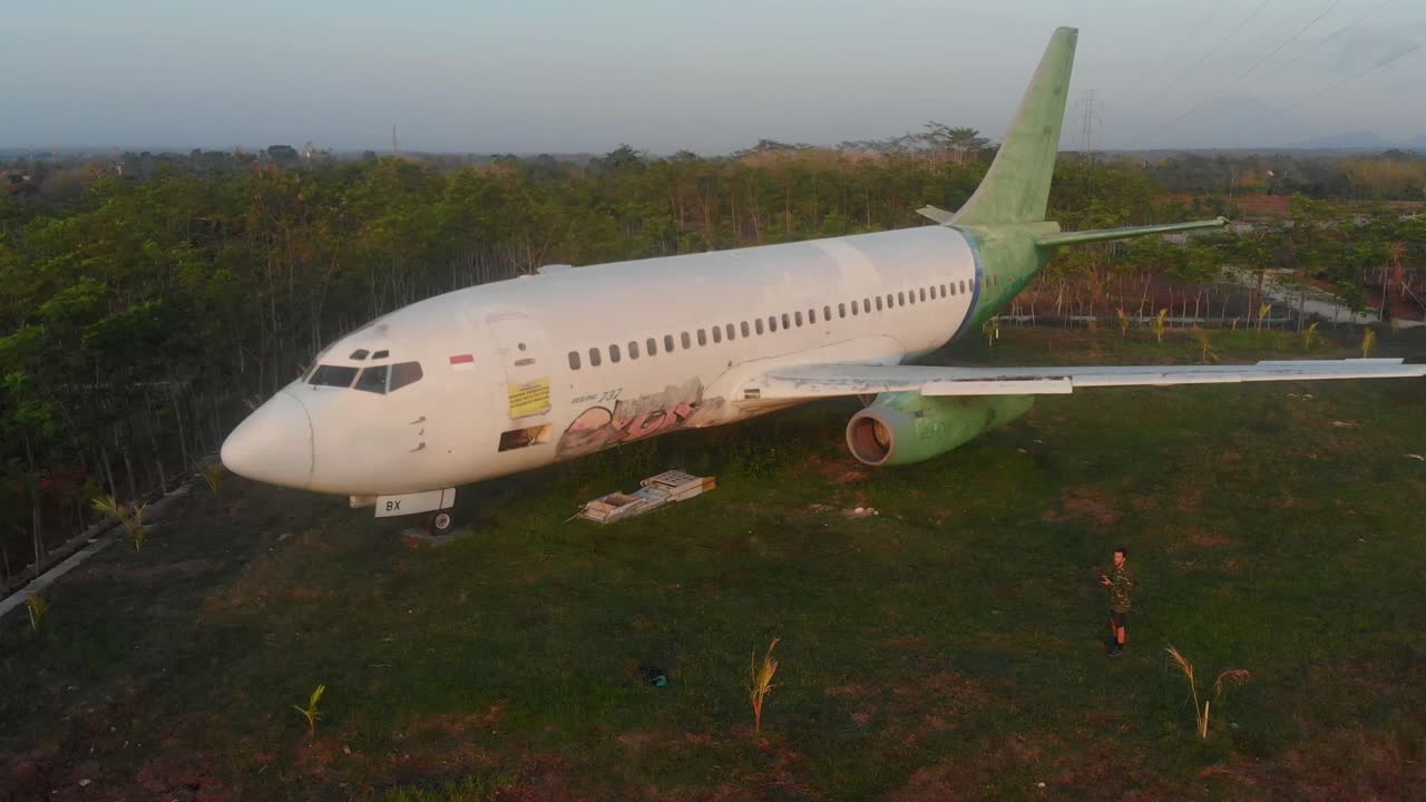 Vista aerea di un aereo abbandonato e fatiscente in un campo erboso durante l'alba a Jembrana, Bali, Indonesia