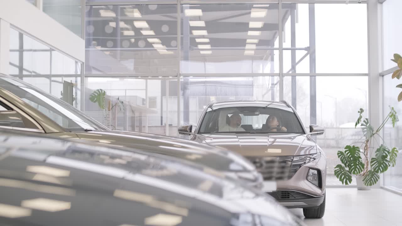 여자 가 자동차 전시실 에서 자동차 를 선택 하고 있다