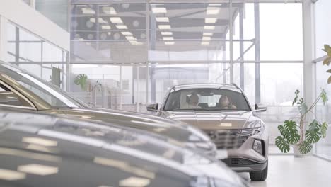 mujer eligiendo un coche en una sala de exposición de automóviles