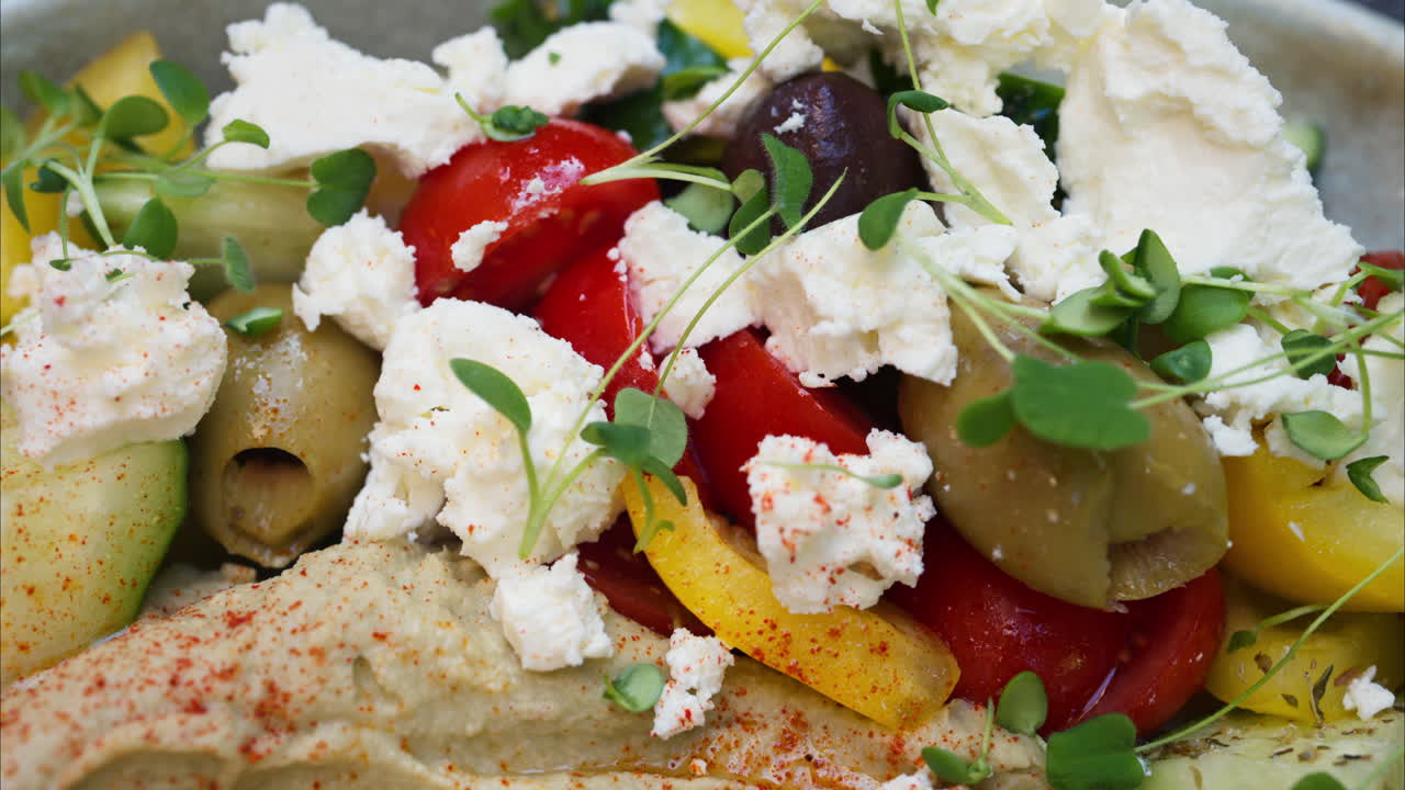 Close up of a greek salad with humus on a table at a terrace