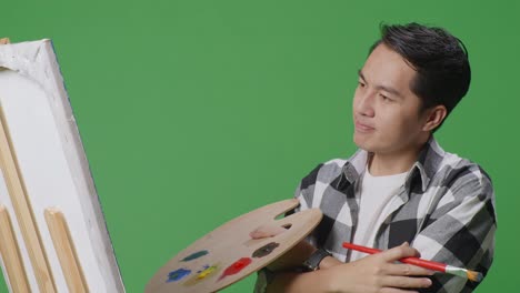 man painting on easel