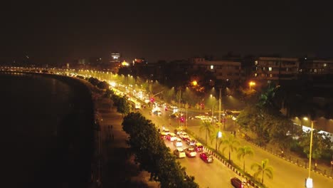 an aerial view with cinematic drone movement of the iconic marine drive nightlife with air india and trident hotel buildings in sight