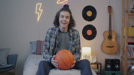 teenager with basketball in a bedroom