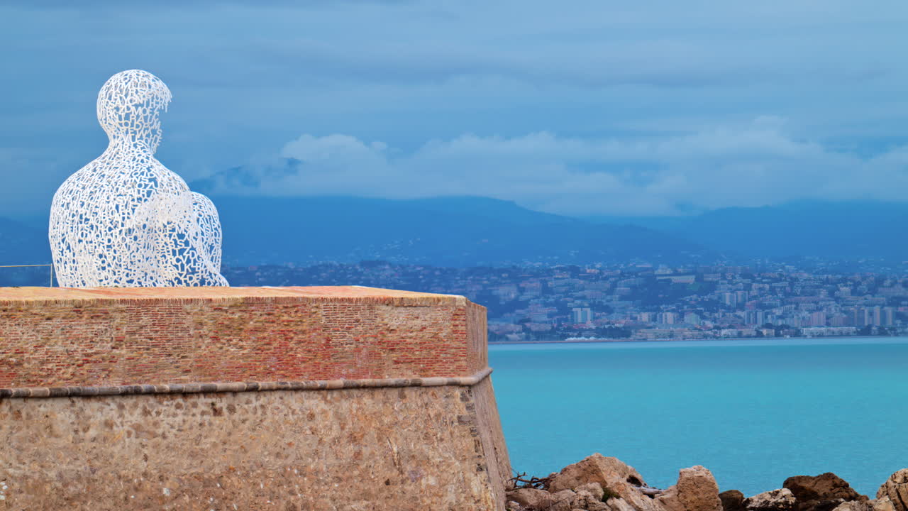 Distant view of The Nomad urban sculpture by Jaume Plensa in the evening in Antibes, France