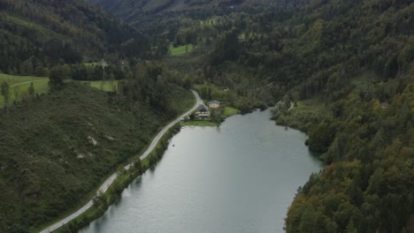 Borde-Sur-De-La-Presa-Del-Embalse-De-Freibach-En-Austria-Con-El-Restaurante-Griego-Stausewirt-A-La-Izquierda,-Toma-Aérea-De-Revelación