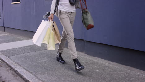 beautiful woman carrying shopping bags walking through city