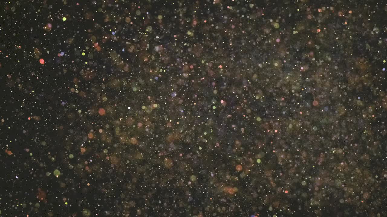 las partículas de brillo flotando en el fondo negro. cámara lenta