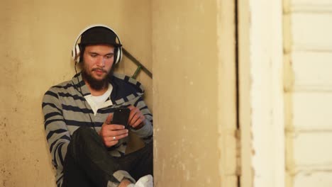 young man listening to music in empty warehouse