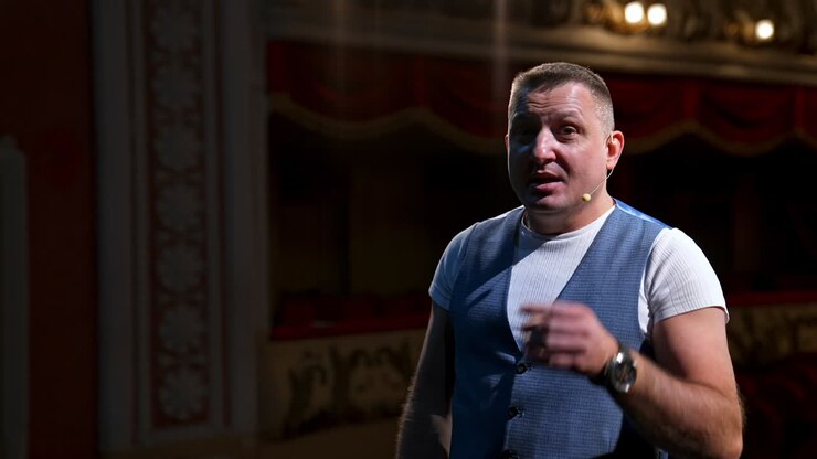 Portrait of a male actor. Middle-aged man speaking during the rehearsal while standing on stage. Comedian in the theater.