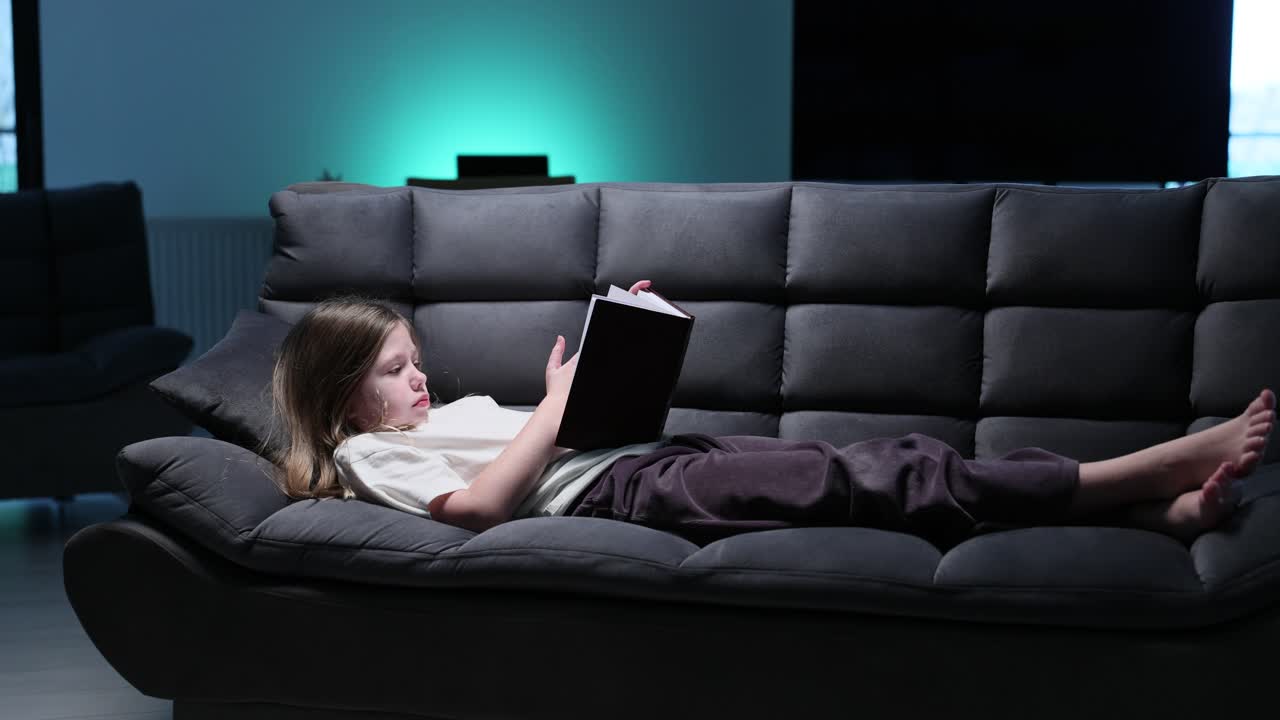 소파에서 책을 읽는 소녀