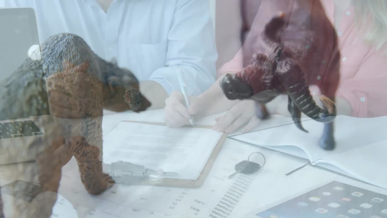 종이 파일에 글을 쓰는 사람들 위에 서로 마주보고 있는 두 마리의 동물 조각상의 애니메이션