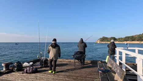 group of fishermen casting lines on pier