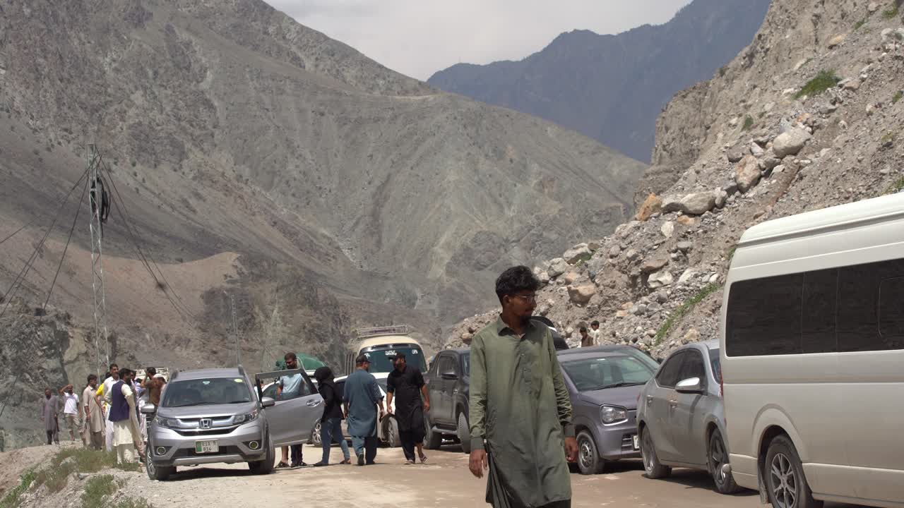 People and cars on a traffic blockade after land sliding, people stuck between mountains, no drive through, static with copy space