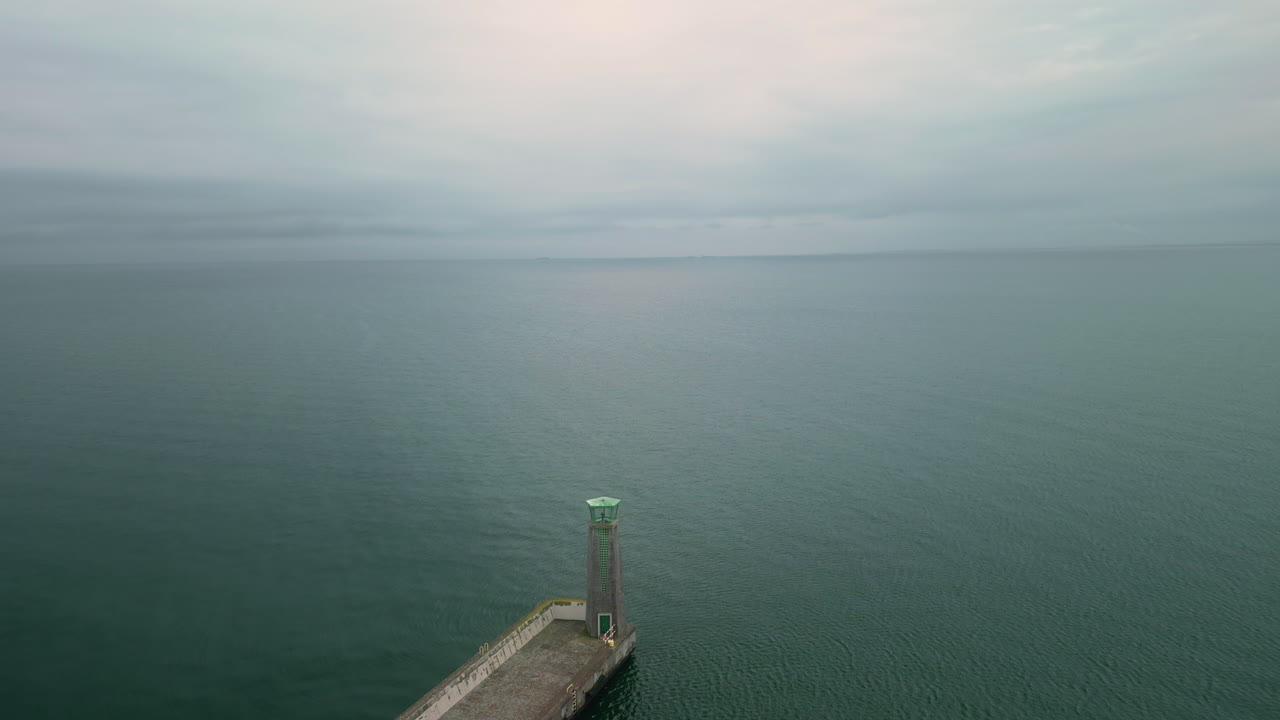 A pier stretching into the sea on a cloudy day