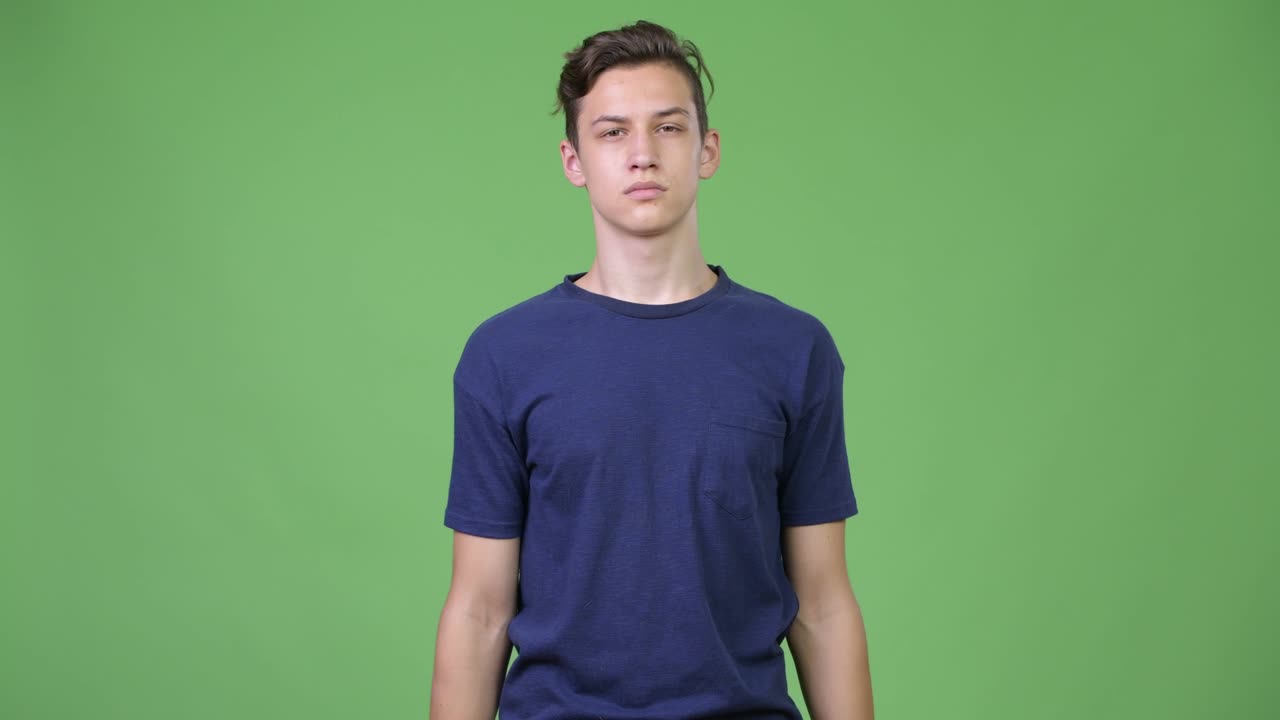 Young handsome teenage boy covering mouth