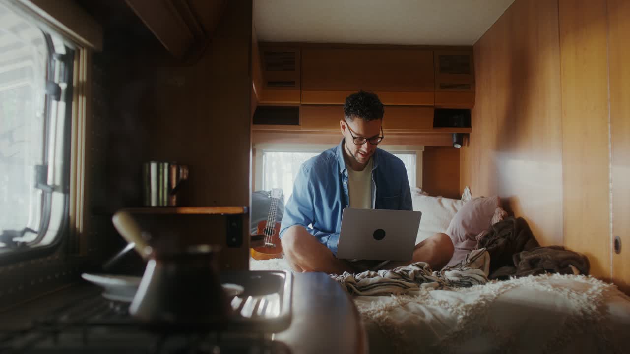 Man Working on Laptop in RV Bedroom