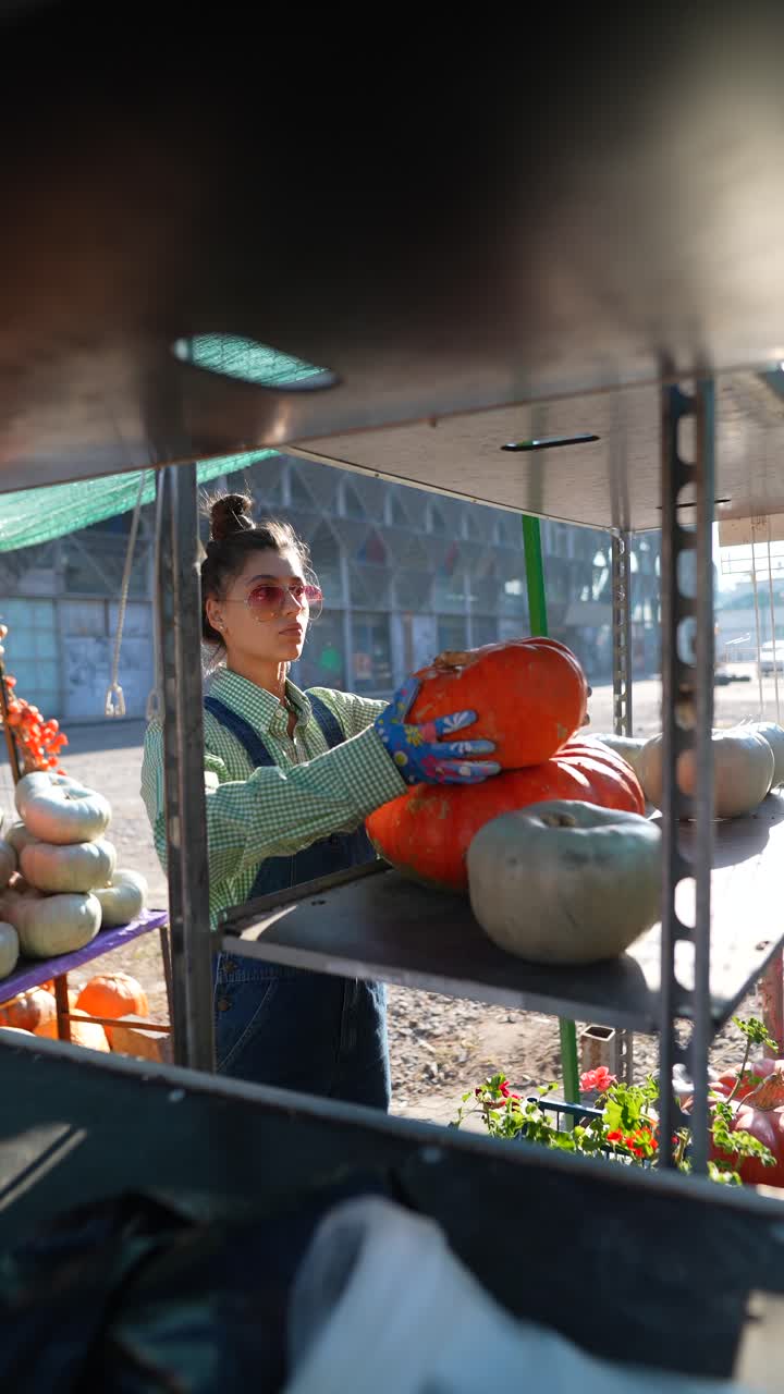 mujer seleccionando calabazas en un mercado de agricultores
