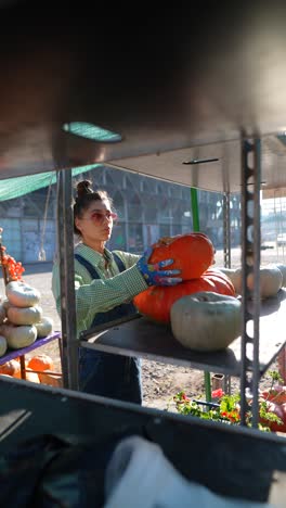 woman selecting pumpkins at a farmer's market