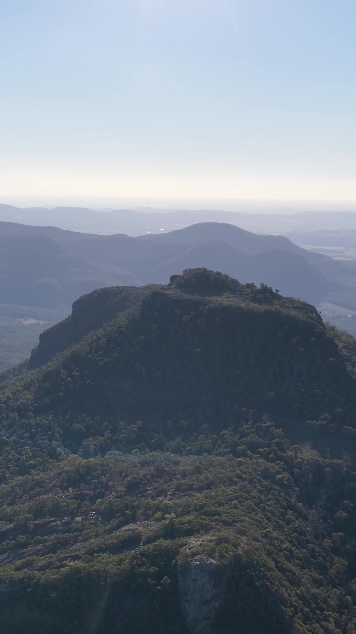 Laaja ilmakuva karuista vuorenhuipuista ja metsästä Warrumbungle National Parkissa, Australiassa