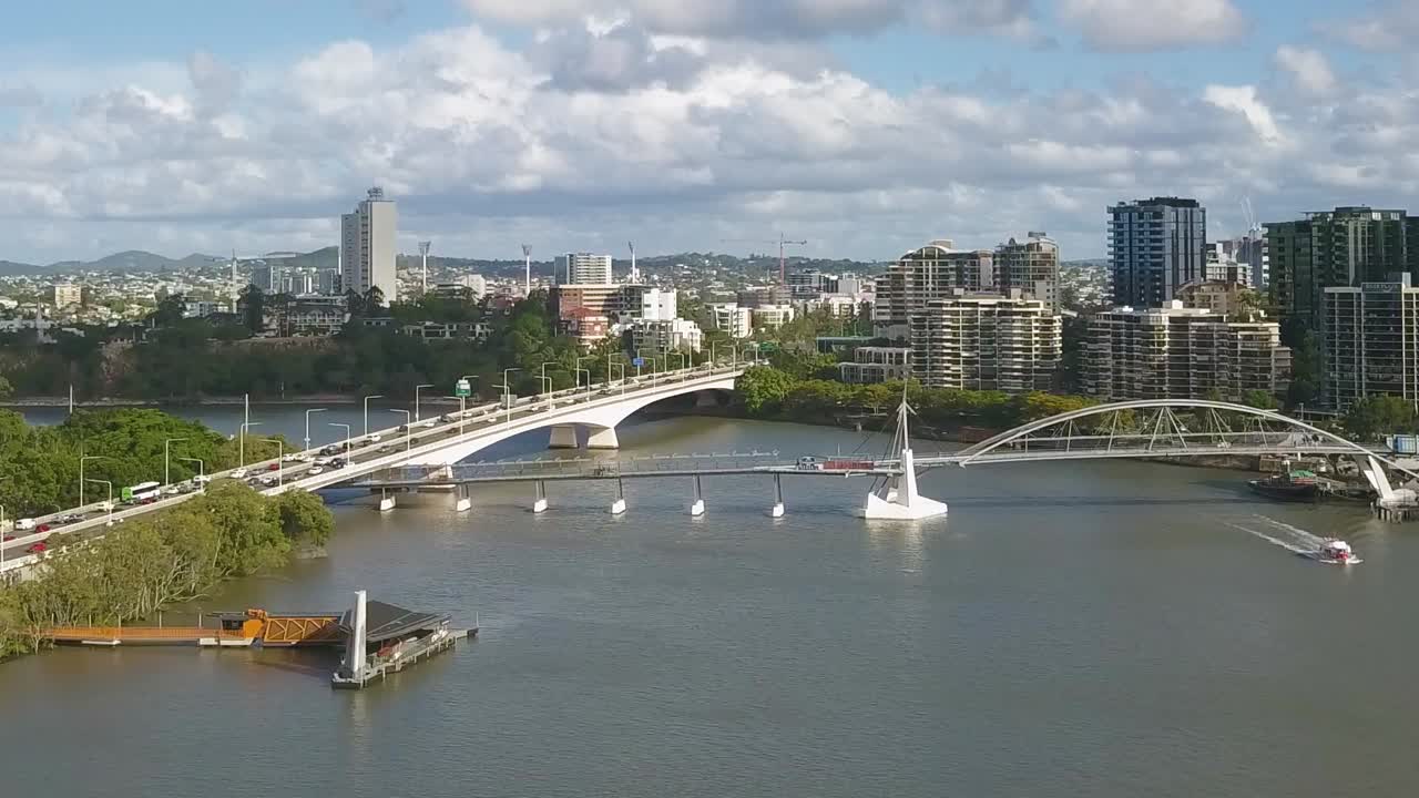 브리즈번 의 피어 와 보행자 다리 와 교차 하는 다리 를 따라 자동차 가 운전 한다