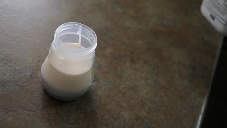 pouring ready to feed formula into baby bottle