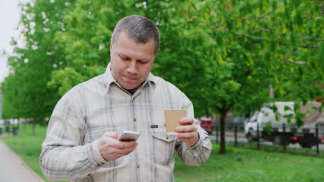 Middle-Aged-Man-Drinking-Coffee-On-The-Go-Walking-On-City-Park