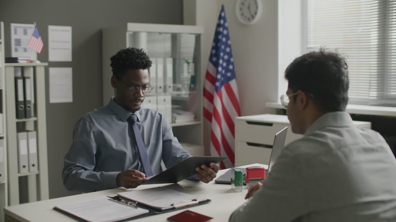Black Consular Officer Conducting Visa Interview with Applicant at US Embassy