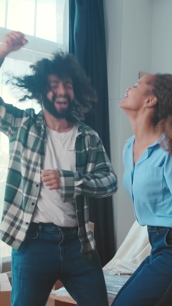 bailando alegremente en una habitación acogedora mientras desempaqueta cajas después de mudarse