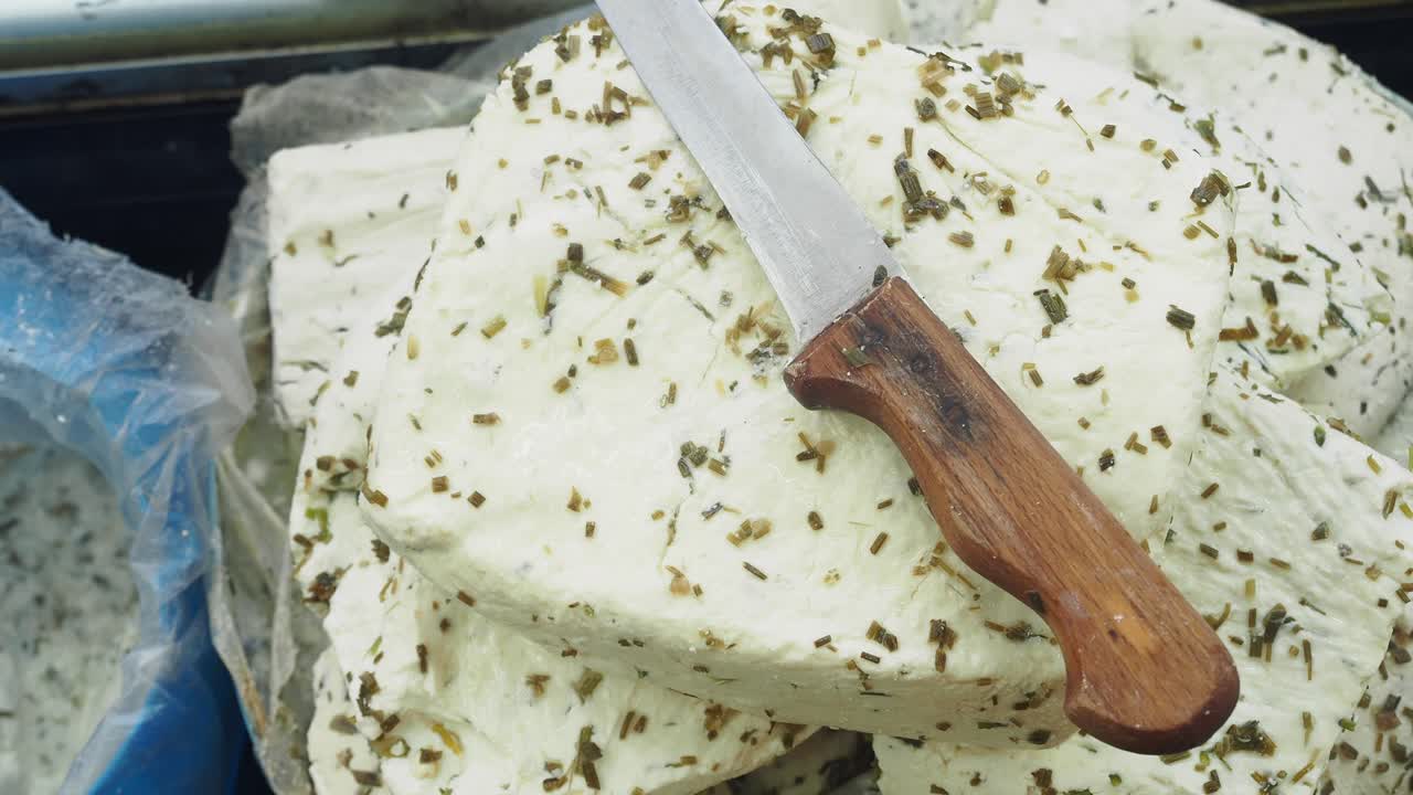 Fresh cheese with herbs and a knife