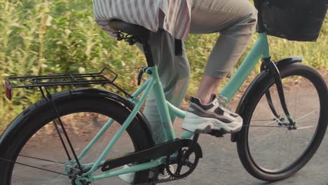 Camera-Focusing-On-The-Feet-Of-A-Woman-Pedaling-A-Bicycle