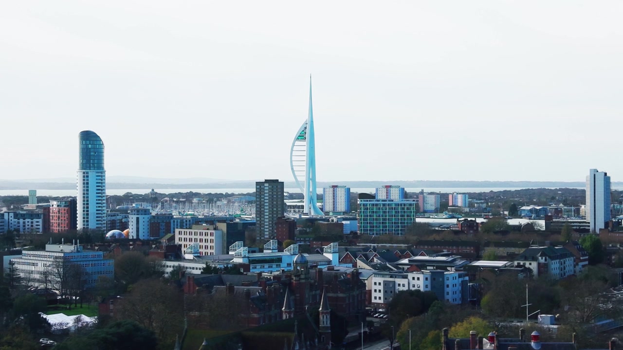 Riprese aeree con drone dello skyline di Portsmouth di giorno, che mostrano la Spinnaker Tower, il porto turistico e gli edifici circostanti della città